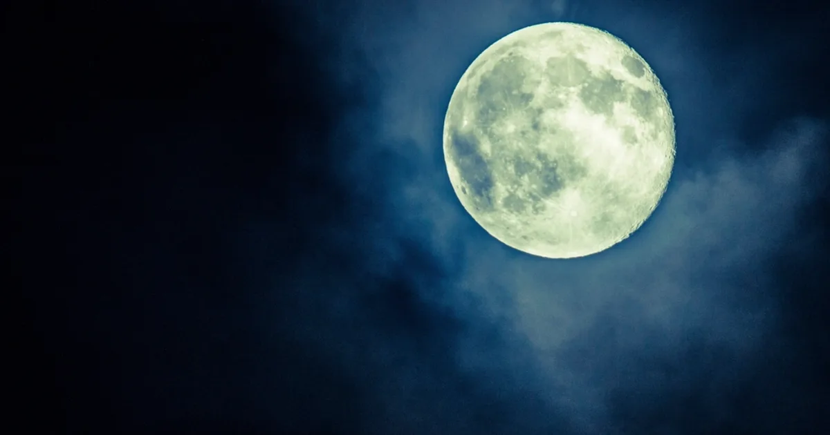 The Moon glowing in a deep blue night sky during the short nights of midsummer